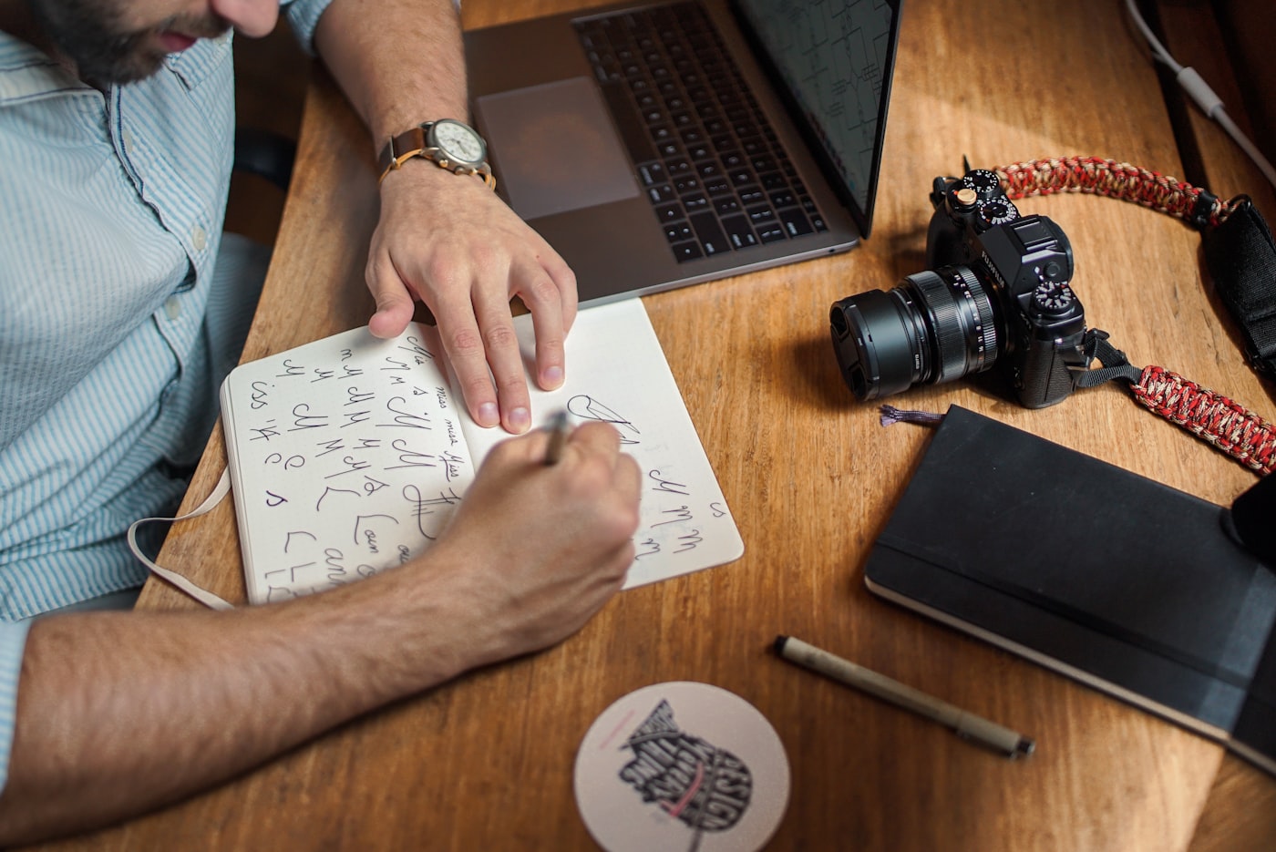 Designer sketching hand-lettering concepts at a studio desk